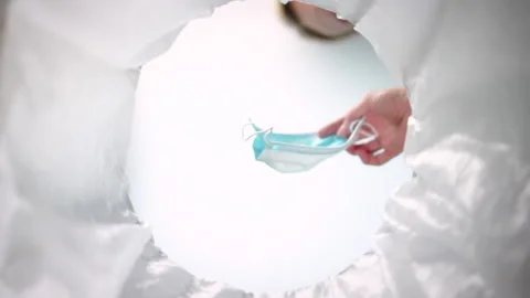 Bottom-up view of a woman throwing face mask into the trash can. Slow-motion Stock Footage 163480018