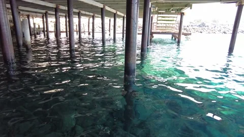 Bottom view of the wooden pier in the middle of the blue sea. Video stock 239486334