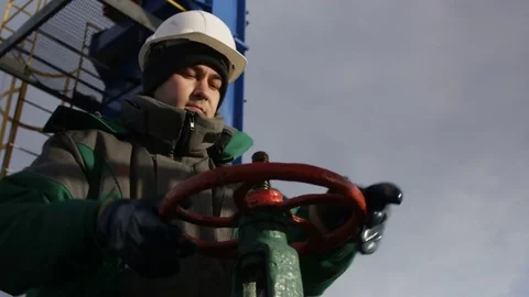 Bottom View Worker Rotates Level at Oil Extracting Well Stock Footage 79208181