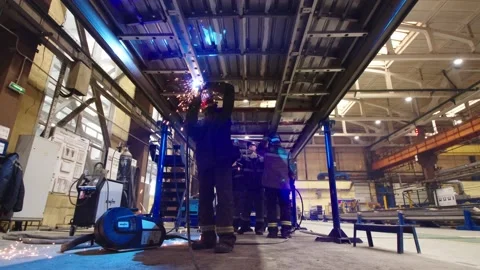 Bottom view of workers in protective uniform and safety masks welding steel Stock Footage 202048994