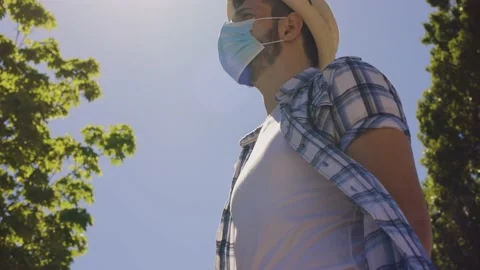 Bottom view of young boy with surgical mask for Covid talking with his friends Stock Footage 155249088