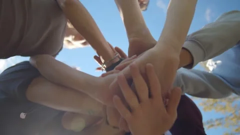 Bottom view of young diverse people putting their hands together outdoors. Stock Footage 139043124