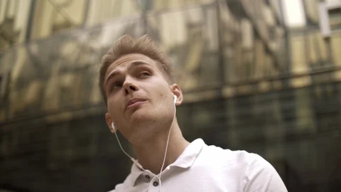 Bottom view of a young stylish funny young guy student listening Stock Footage 114454177