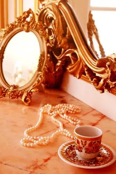 Boudoir. Table with mirror and woman's accessories. pearl necklace, antique m Stock Photos