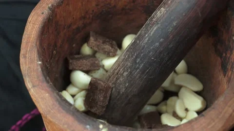 Bouillon cube and garlic in a mortar and a pestle Stock Footage 232053238