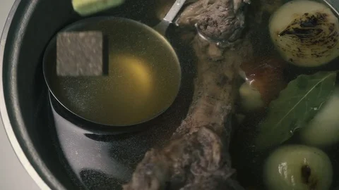 The bouillon cube falls into a saucepan with beef bouillon, slow motion Stock-Footage 73741069