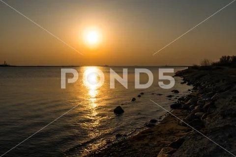 Boulder beach sunset with clear sky and beautiful vivid warm colors Stock Photos