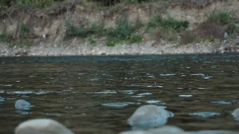 Boulder falls into the blue water and makes big splash and waves Slow motion Stock Footage 82956700