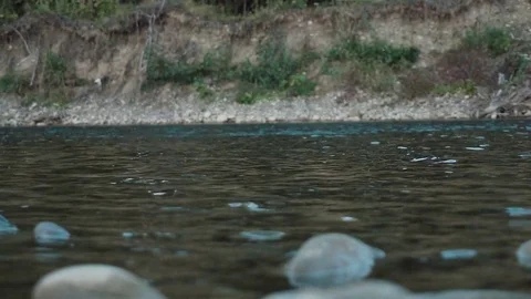Boulder falls into the blue water and makes big splash and waves Slow motion Stock Footage 82956809