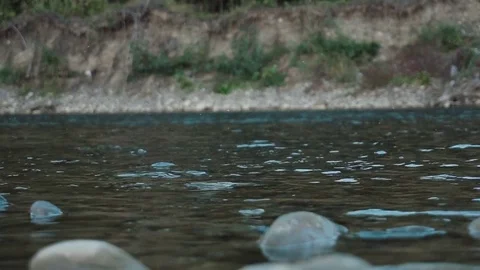 Boulder falls into the blue water and makes big splash and waves Slow motion Video stock 82956942