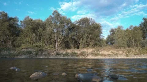 Boulder falls into the calm blue water and makes big splash and waves 4k Stock Footage 82740485