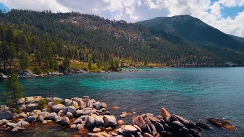 Boulder headland and mountain slopes beside Lake Tahoe. Rounded granite rocks Stock Footage 346532671