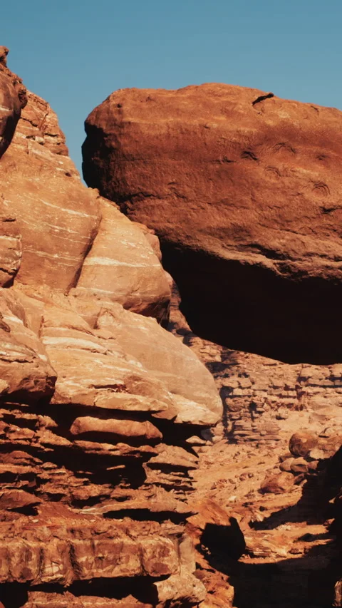 Boulder resting on rocky terrain in a desert landscape during daylight hours Stock Footage 340870923