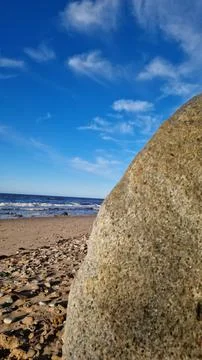 Boulder on Sandy Beach with Waves and Sky Stock Photos
