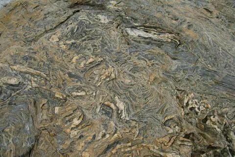 Boulder surface texture in shades of grey, brown and yellow - top view. Stock Photos