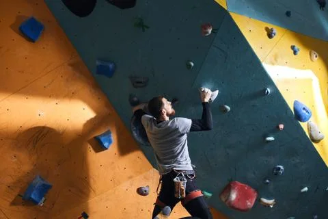 Boulderer with physical disability after warming up, training at climbing wall Stock Photos