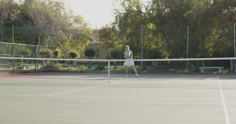 Bouncing ball on racket African American man serving shot and woman returning on 動画素材 345062005