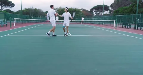 Bouncing ball before serving, Diverse male teammates exchanging fist bump on Видео 343836861