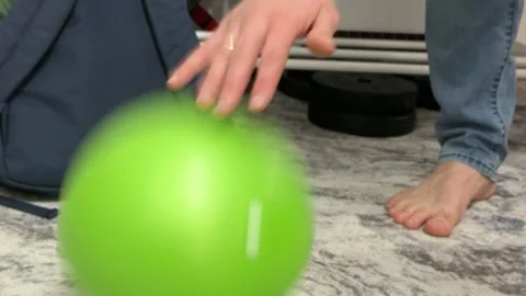 Bouncing a green rubber ball repeatedly on the carpet Stock Footage 335074266
