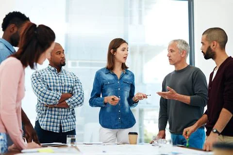 Bouncing ideas off of one another. a group of architects working on blueprints Stock Photos
