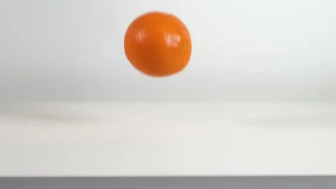 Bouncing orange on white table Stock Footage 145326720