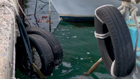 Bouncing tires on the water at a dock in a coastal area during daytime Video stock 347325347