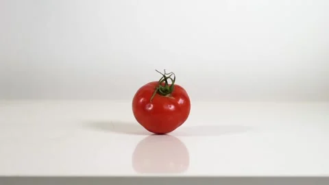 Bouncing tomato on white table Stock Footage 145326727
