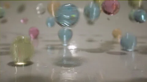 Bouncing water beads slow motion Stock Footage 144704166