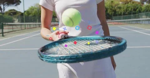 Bouncing yellow ball on blue racket woman in tennis attire on tennis court, with Foto stock