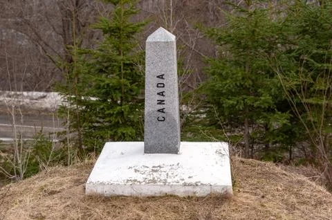 A boundary stone marks the US/Canada border. Stock Photos