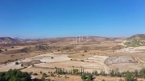 Boundless fields with shrubs and road against wind turbines Stock Footage 150875280