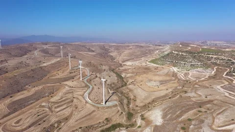 Boundless fields with shrubs and road against wind turbines Stock Footage 150940505