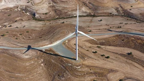 Boundless fields with shrubs and road against wind turbines Stock Footage 150974025