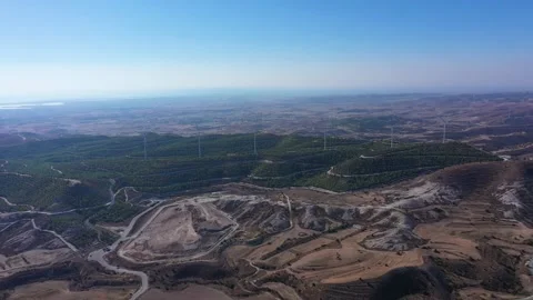 Boundless fields with shrubs and road against wind turbines Stock Footage 150974233