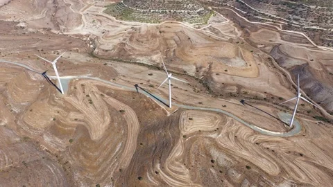 Boundless fields with shrubs and road against wind turbines Stock Footage 151112216