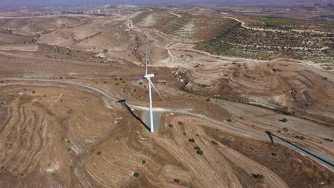 Boundless fields with shrubs and road against wind turbines Stock Footage 151112227