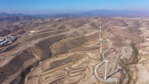 Boundless fields with shrubs and road against wind turbines Stock Footage 151112385