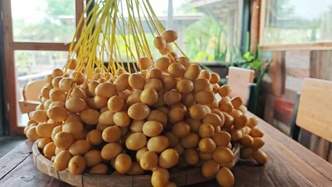 Bountiful Fresh Yellow Date Palm Bunch on Wooden Table. Stock Footage 340488248