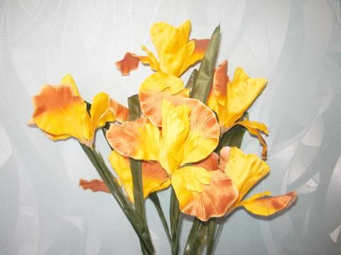 A bouquet of artificial flowers iris which lies on the windowsill Stock Photos
