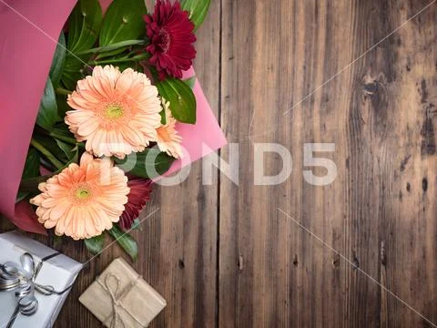 Bouquet of flowers on old wood background. Gift boxes tied with ribbon and rope Stock Photos