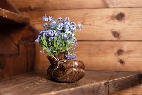 Bouquet forget me not flowers in a ceramic vase on a wooden background. Stock Photos