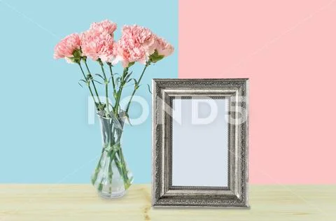 Bouquet of pink carnation flowers and empty silver photo frame Stock Photos