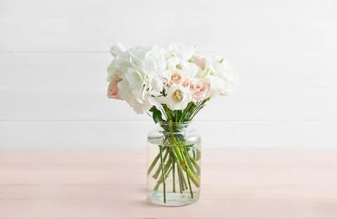 Bouquet of roses, eustomas and hydrangeas on table. Cup of tea and photo fram Foto stock