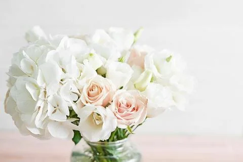 Bouquet of roses, eustomas and hydrangeas on table. Cup of tea and photo fram Stock Photos