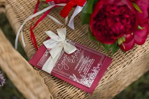 A bouquet of ruby flowers on a wicker chair 2800. Stock Photos