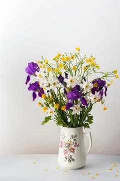Bouquet of spring flowers, irises and yellow ranunculus with white daffodils Stock Photos
