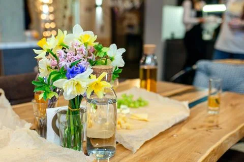 A bouquet of spring flowers on the kitchen table. Daffodils, hyacinths in a vase Stock Photos