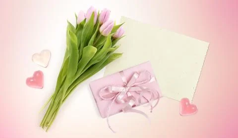 Bouquet of tulips, card, hearts and box gift on pink background Stock Photos