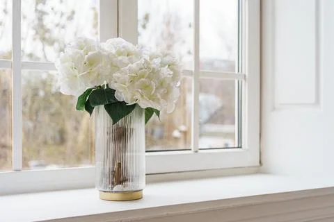 Bouquet of white artificial decorative hydrangea, hortensia in vase on wind.. Stock Photos