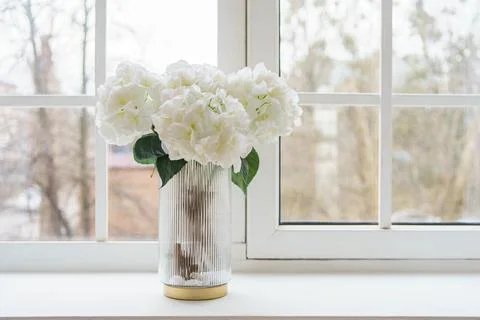 Bouquet of white artificial decorative hydrangea, hortensia in vase on wind.. Stock Photos